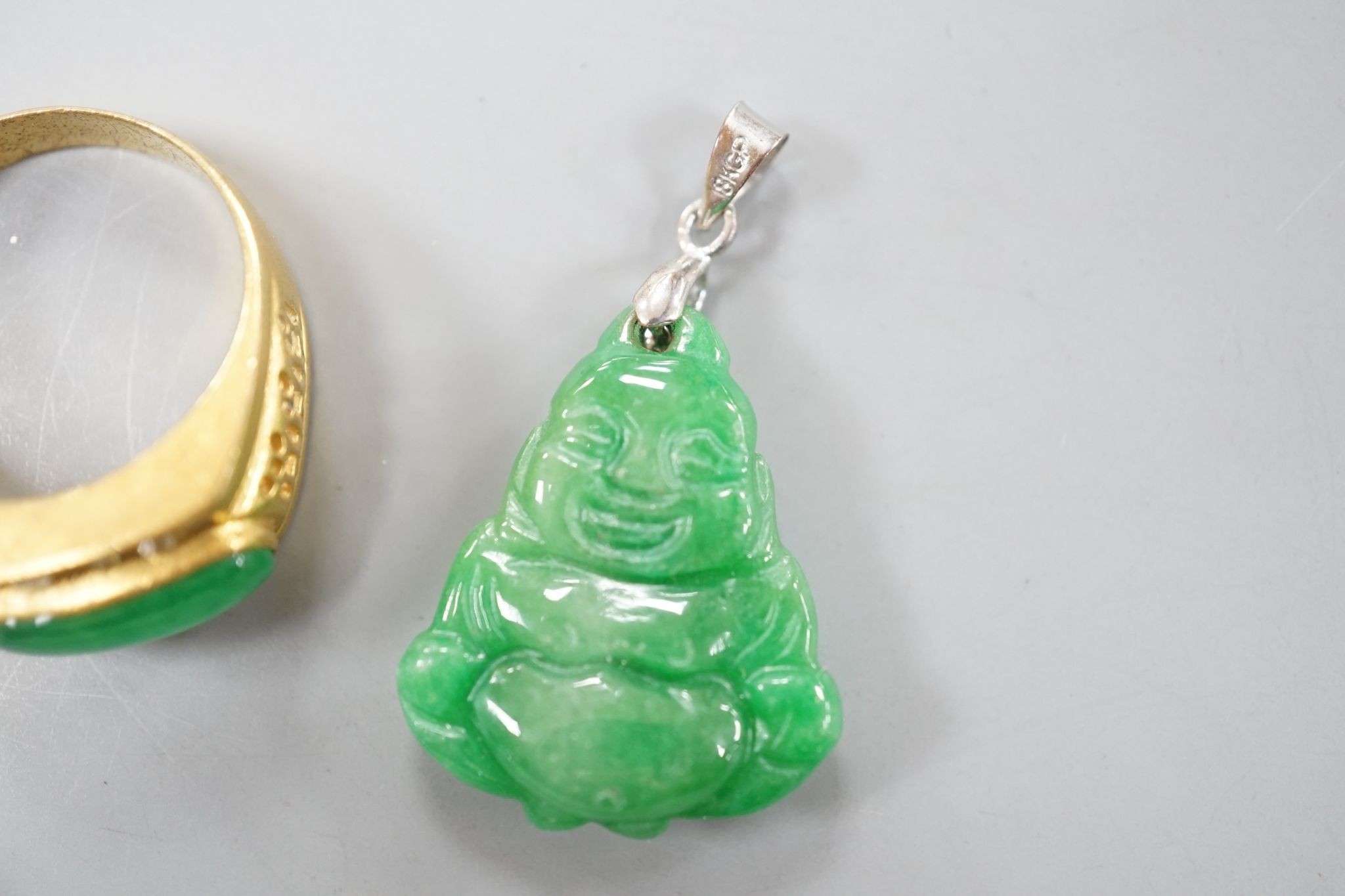 A carved jade pendant, 53mm on a quartz bead necklace, one other jade pendant and a jade, paste and gilt metal ring.